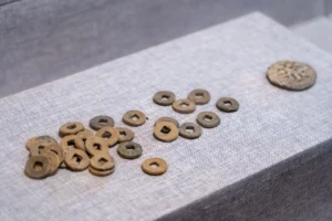 Old Chinese coins with square holes laid out on fabric