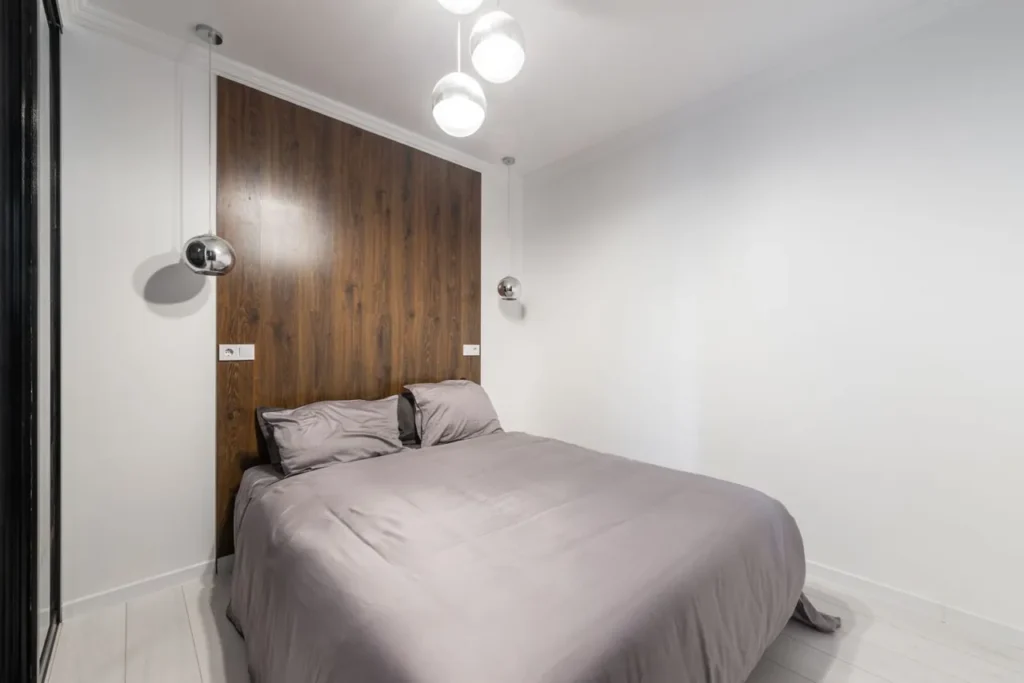 Bed with its head against a solid panelled wall