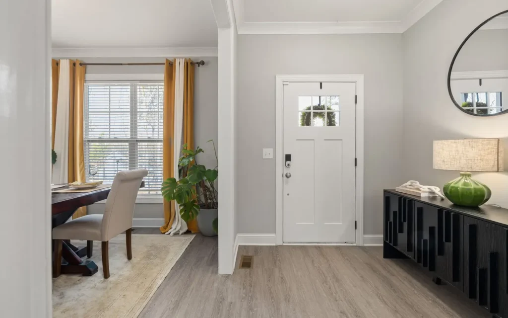 Bright entryway with a console, plants and a white front door