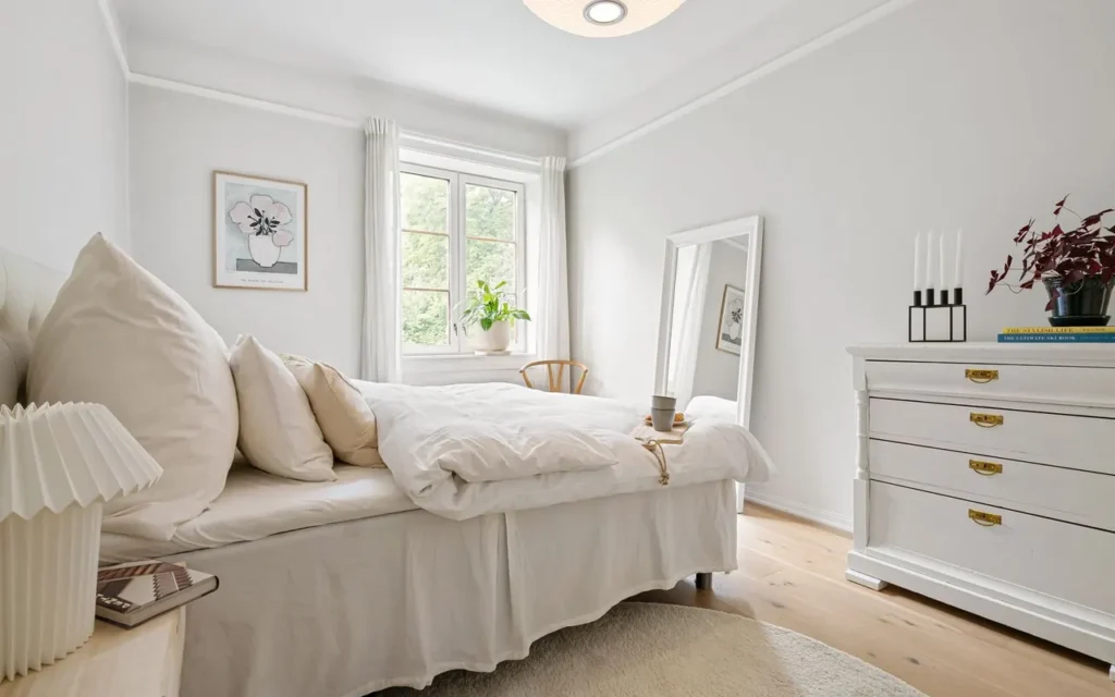 Bright minimal bedroom with white bedding and houseplants
