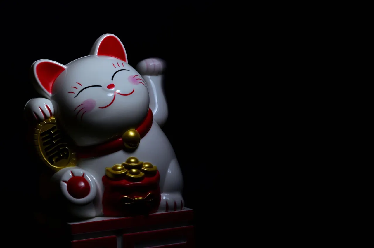 White ceramic maneki-neko lucky cat with a raised paw