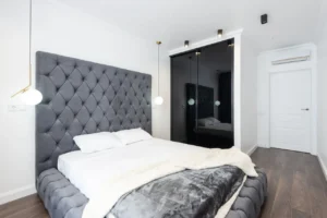 Bed with a solid grey upholstered headboard