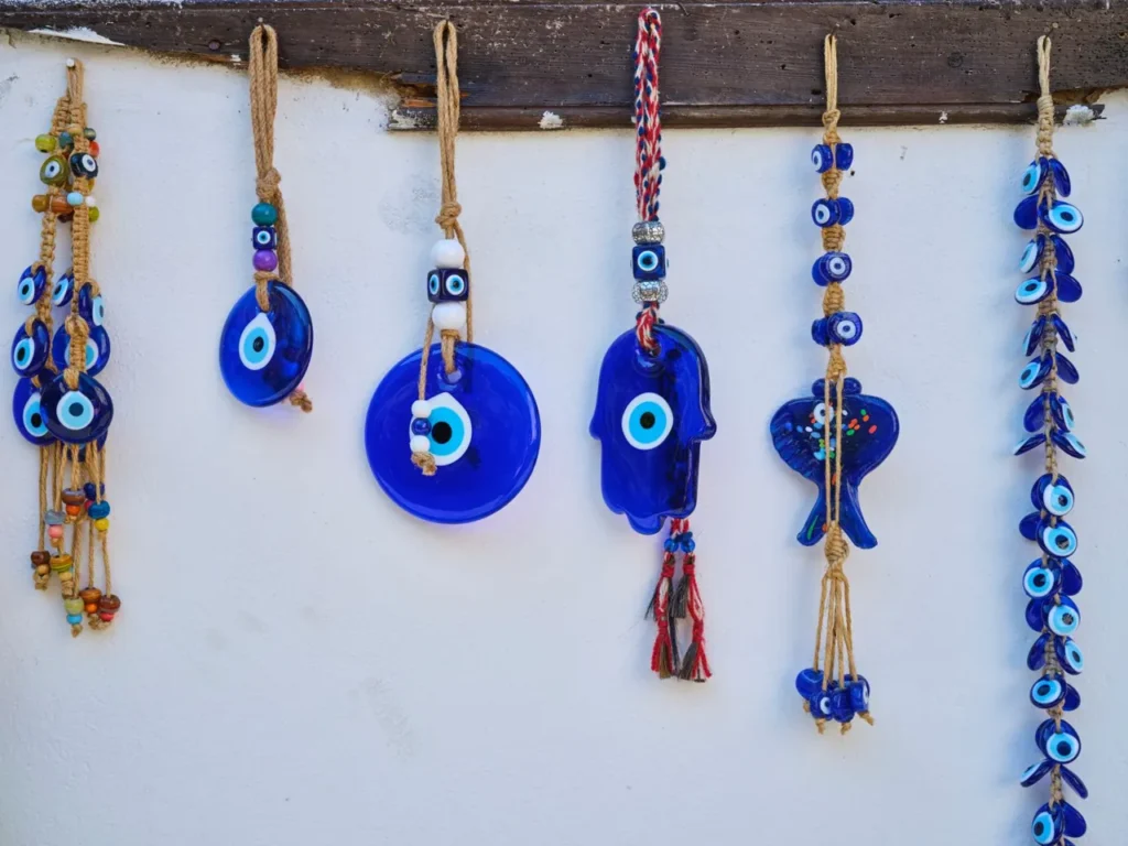 Handmade blue evil eye charms hanging on a white wall