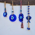 Handmade blue evil eye charms hanging on a white wall