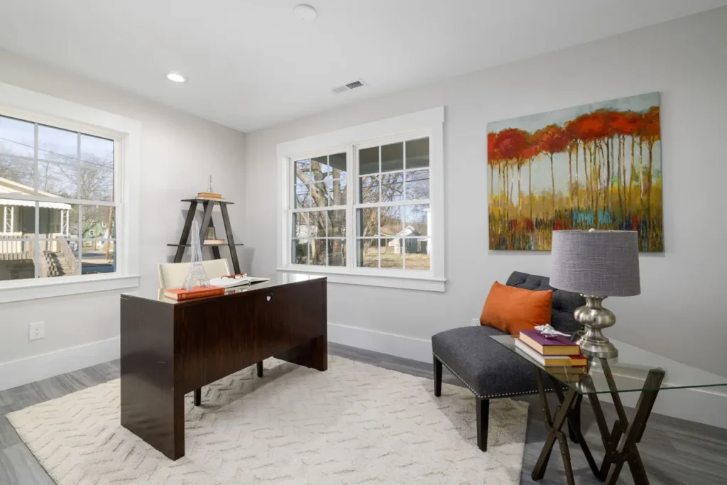 Home office desk in a room with large windows
