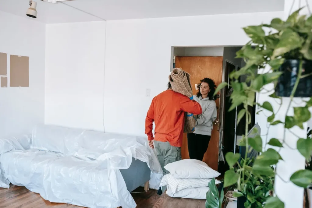 Carrying a rolled rug while rearranging a flat