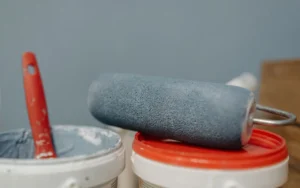 Paint roller resting on an open paint tin
