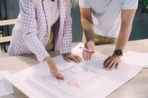 Two people reviewing a floor plan together at a desk