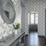 Round decorative mirror on a patterned hallway wall