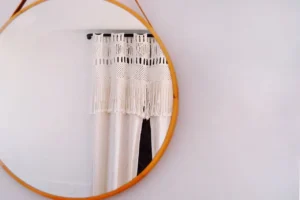 Round brown-framed mirror on a white wall