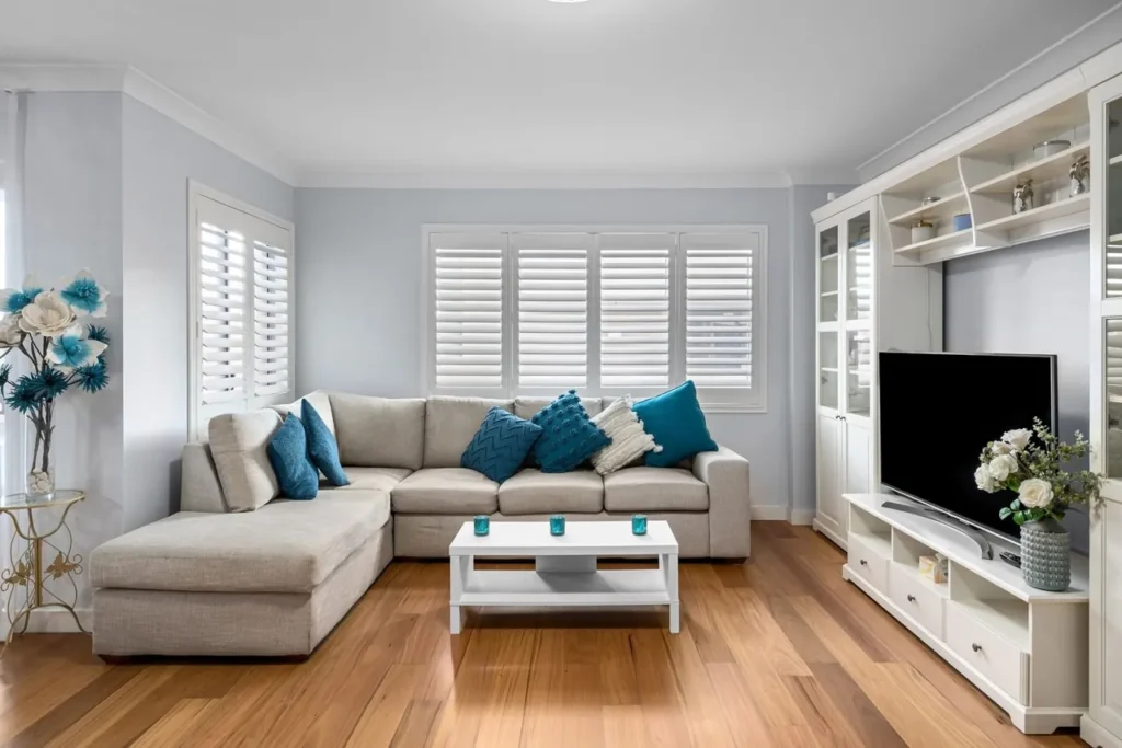 A One-Room Feng Shui Reset in an Afternoon Tidy living room with a grey sofa and blue accents